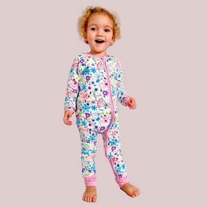 Child wearing a colorful floral onesie on a white background