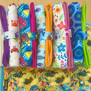 Colorful fabric wraps with various patterns on a wooden surface