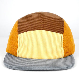 Multicolored cap with brown, yellow, and gray sections on a white background