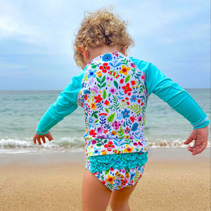 Child in a colorful swimsuit walking on a beach