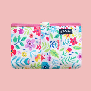 Floral-patterned baby change mat with pink trim on a white background