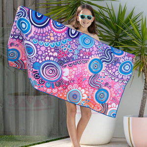 Woman holding a colorful patterned towel by a poolside