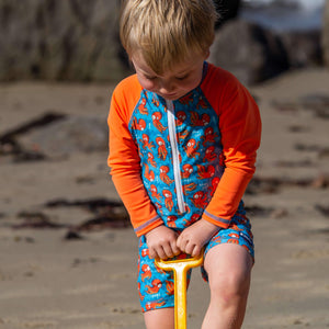 little-boy-playing-in-neon-orange-octupus-all-in-one-swimsuit