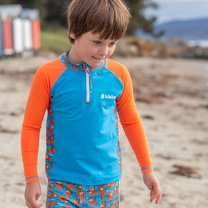 Little-boy-standing-in-sun-safe-long-sleeve-two-piece-neon-octopus-check