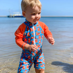 baby-boy-standing-in-tangerine-octopus-long-sleeve-sun-safe-swimwear