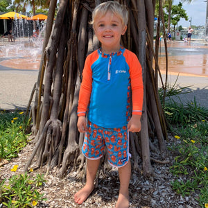 Little-boy-standing-in-easy-to-spot-easy-change-octopus-rashguard-and-boardshorts